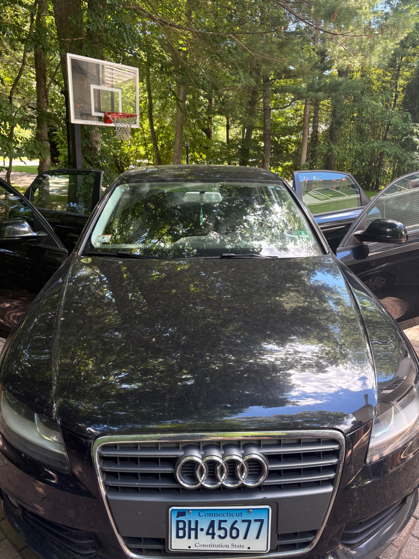 Black Audi sedan before detailing — dusty paint with water spots